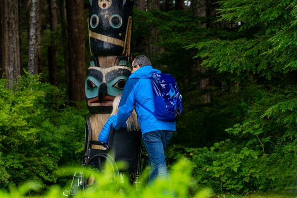 A couple meets up close with a totem pole in Sitka National Historical Park.